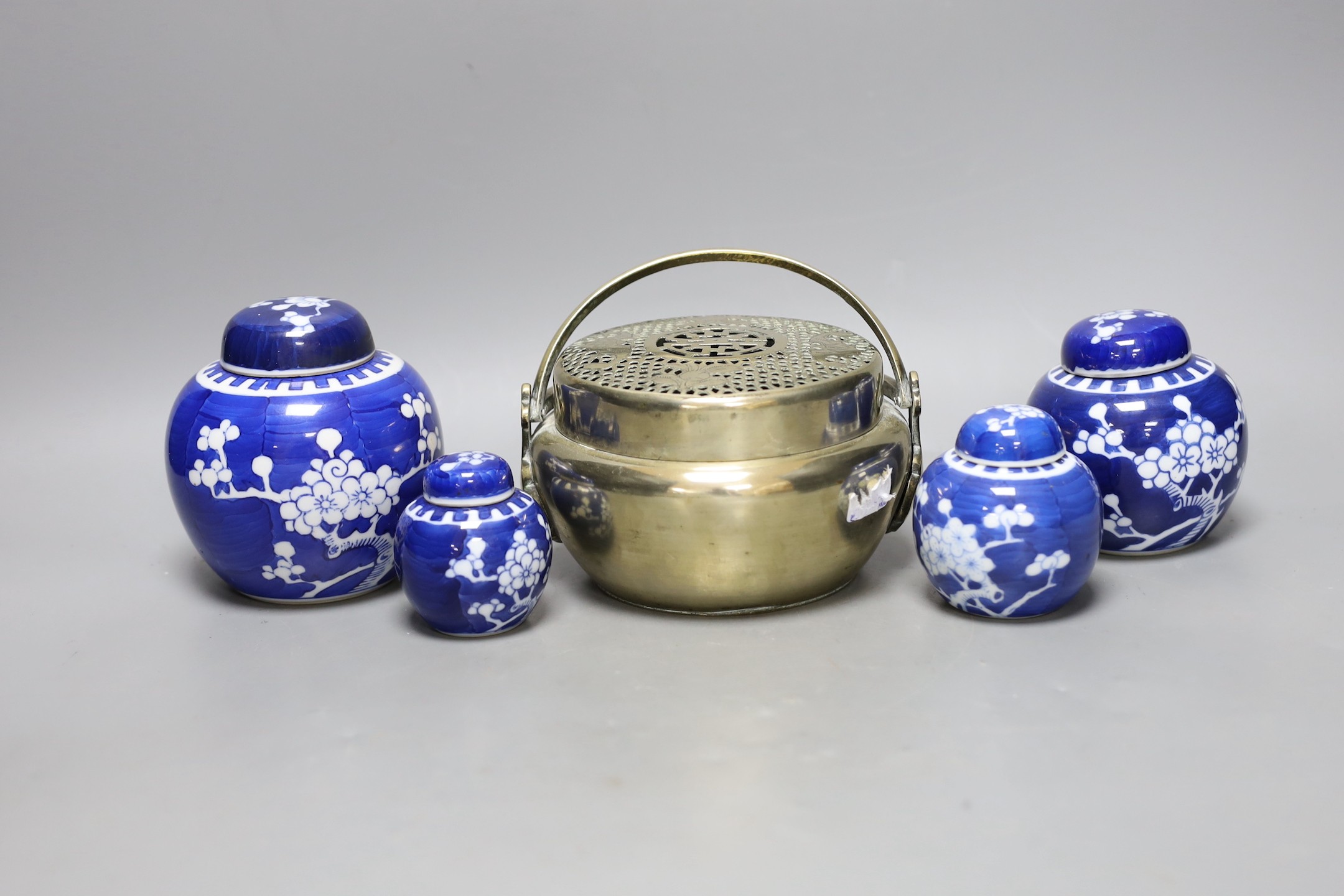 A Chinese bronze hand warmer and four Chinese blue and white Prunus jars and covers. Tallest 12cm